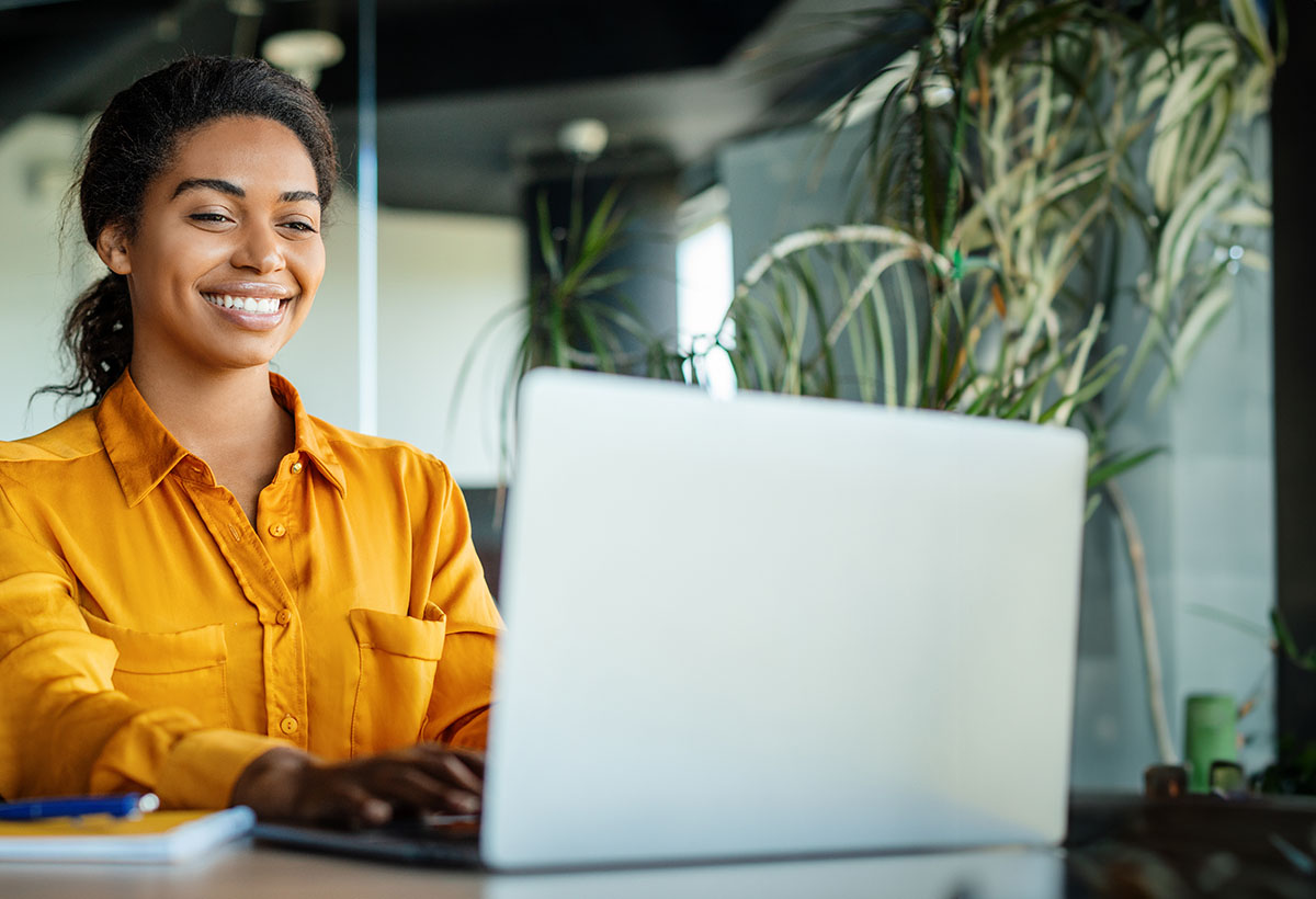 young professional woman on laptop smiling